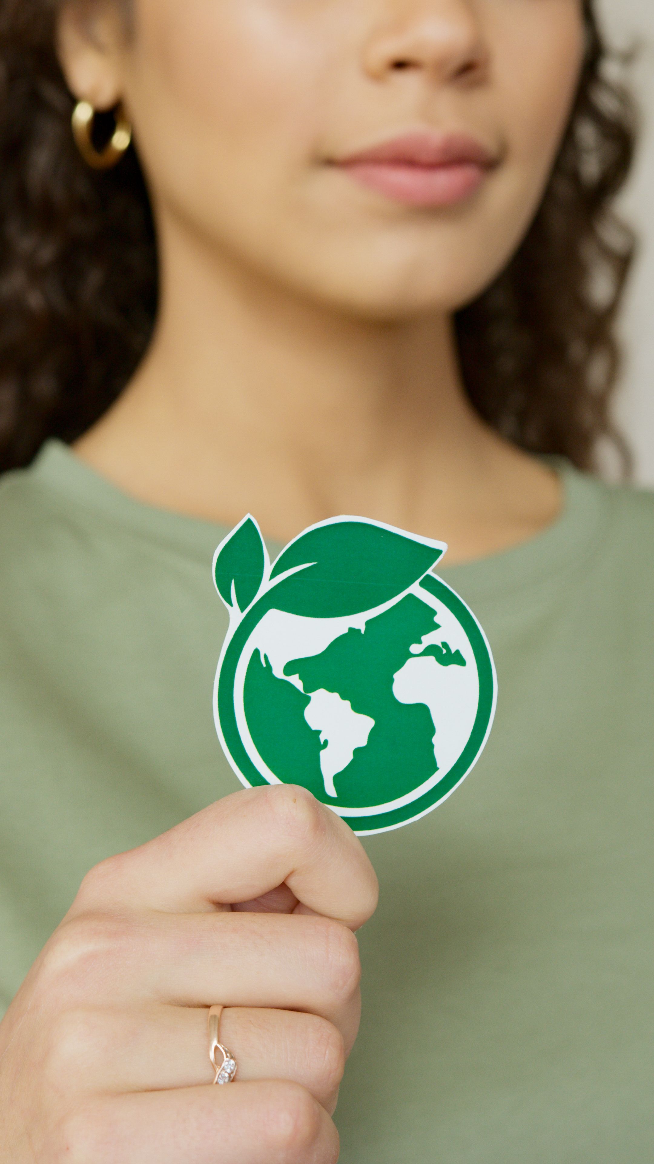 Person holding a green planet symbol